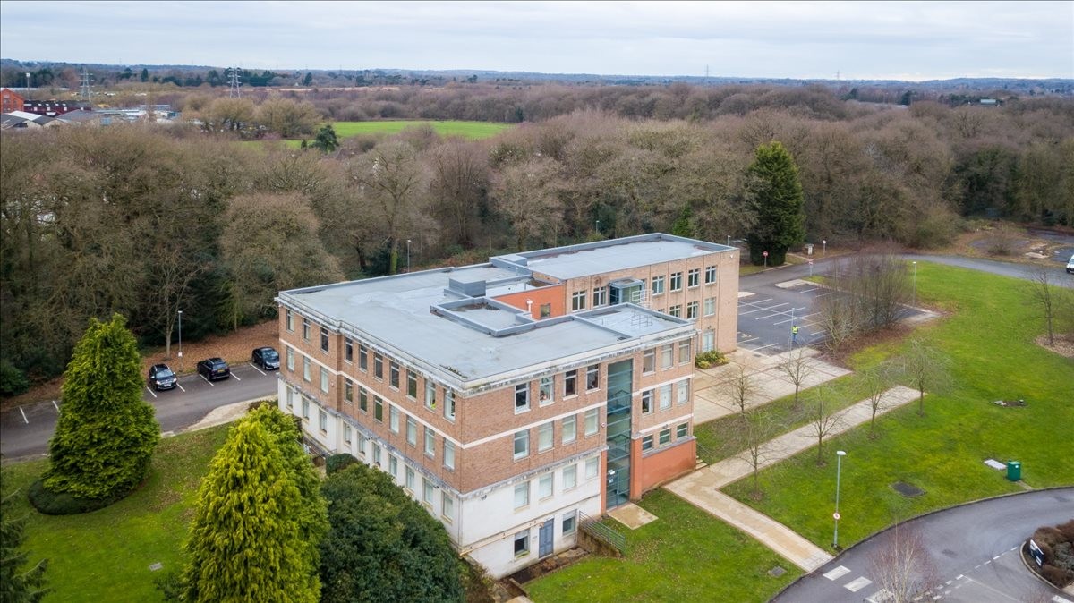 High-angle exterior view of the brick Hooton Business Centre, Hooton Road surrounded by trees.