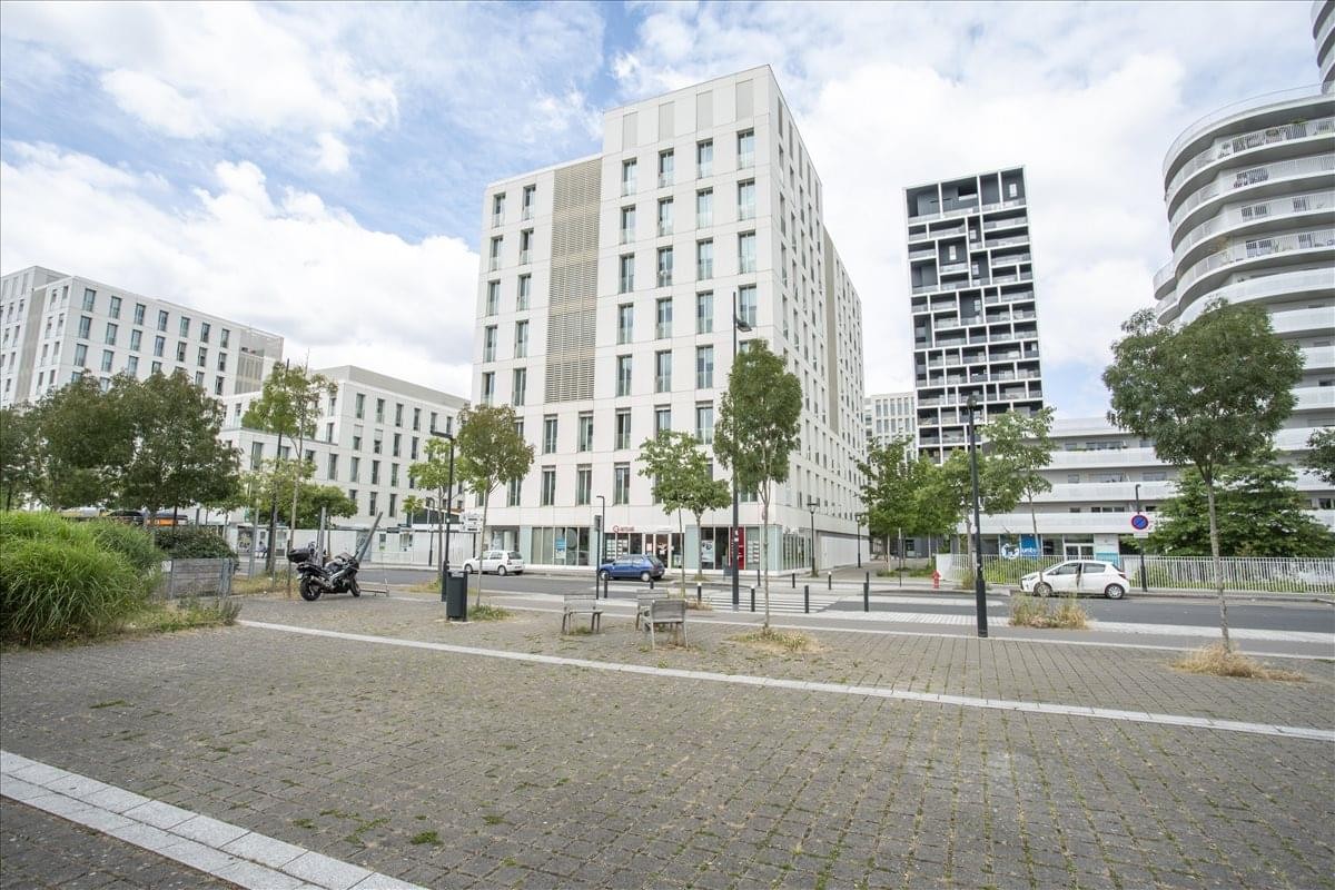 Exterior view of the modern, multi-story Immeuble SKYLINE building under a blue sky.