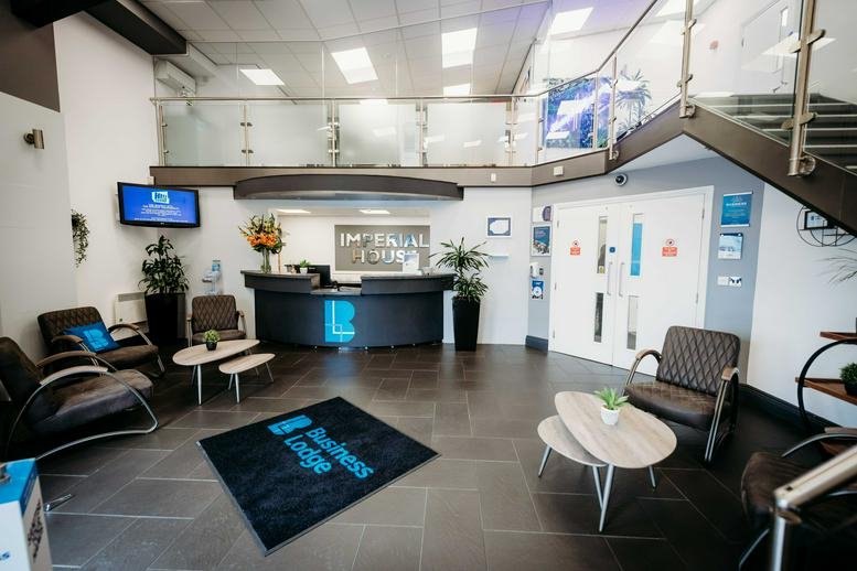 Modern lobby with a curved black reception desk and seating area.