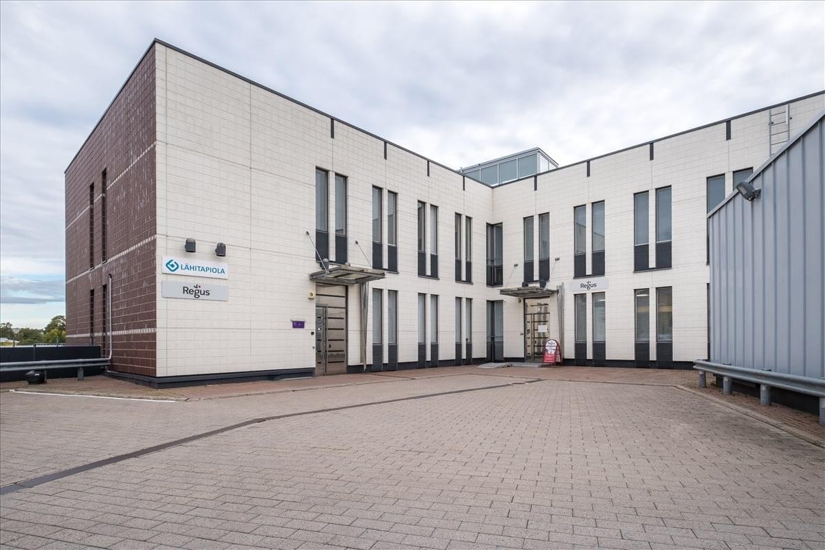 Exterior view of the modern white and brick facade at Itäkatu 1-5, Helsinki.