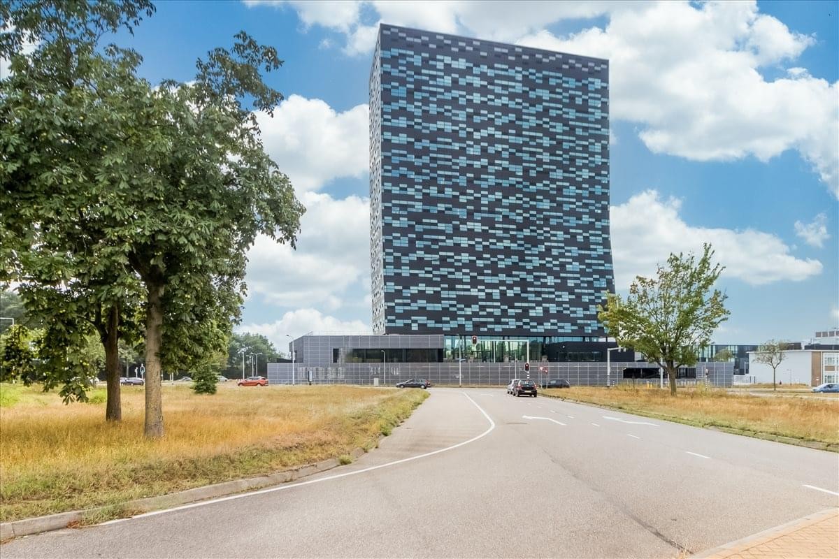 Exterior view of the tall glass and geometric patterned facade at Jonkerbosplein 52, Nijmegen.