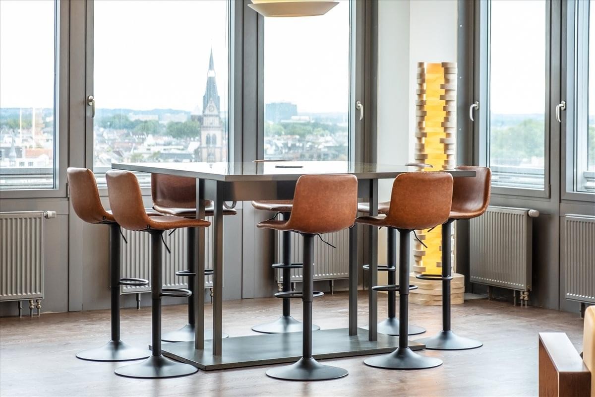 Spacious communal lounge at Kölnturm, Im Mediapark 8 featuring high tables and city views.