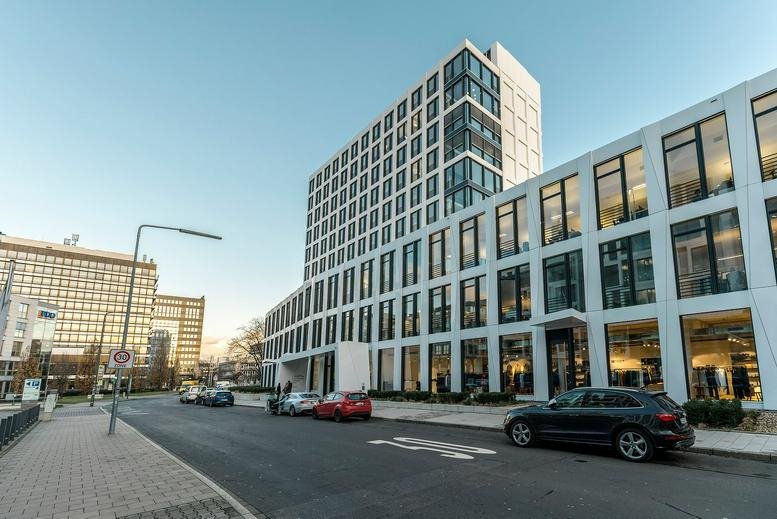 Exterior view of the white grid-facade building at Kaiserswerther Straße 215.