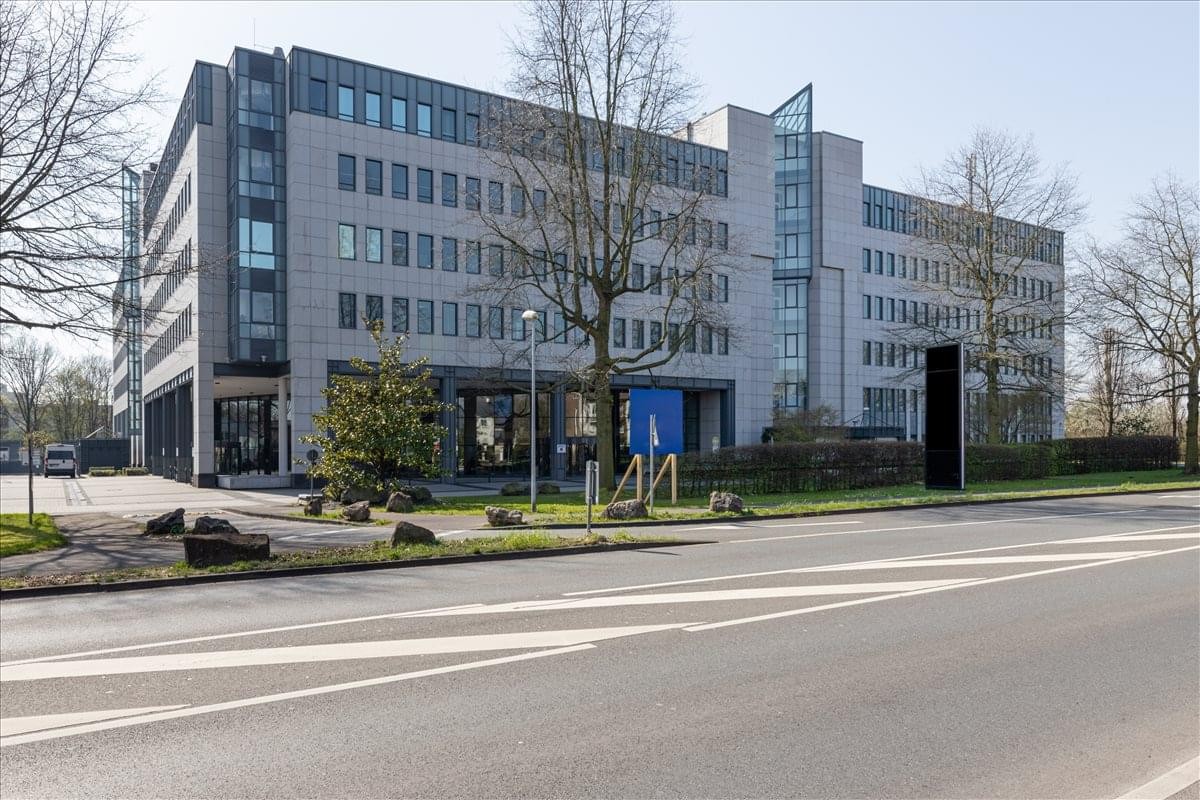 Exterior view of the modern stone and glass facade of Kaiserwerther Str 115.