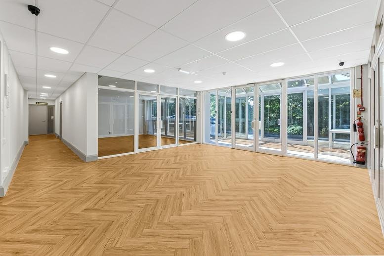 Spacious reception area with herringbone wood floors and floor-to-ceiling windows at Kingfisher House.