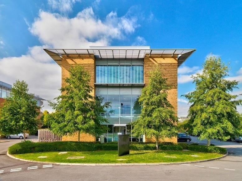 Modern exterior of Kingston House at Lydiard Fields Business Park with glass facade and landscaped trees.
