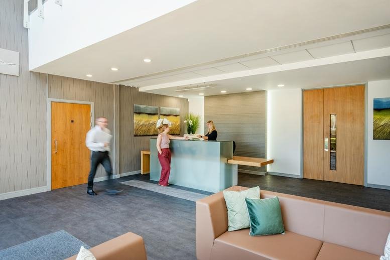 Spacious reception area at Kingston House, Lydiard Fields Business Park, with a sleek desk and lounge seating.