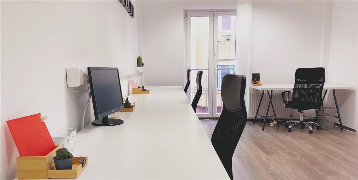 Spacious, modern reception area at Konigsallee 61 with curved white desk and blue carpeting.