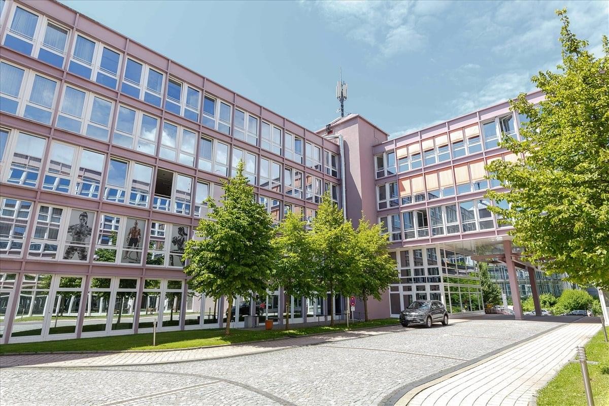 Exterior view of the multi-story office building at Kronstadter Str. 4 with a courtyard and green trees.