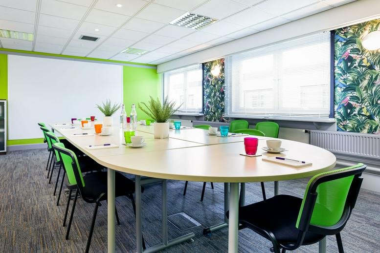Spacious boardroom at Liberty House, 15 Cromarty Campus featuring green chairs and a bright feature wall.