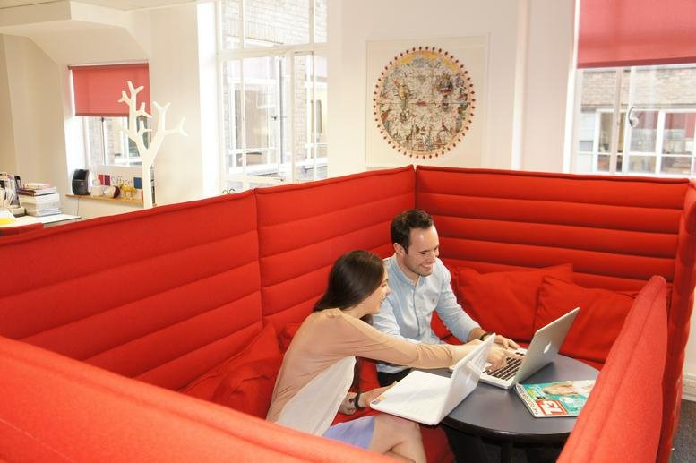 Spacious red breakout pod at Lincoln House, 300 High Holborn with two people working on laptops.
