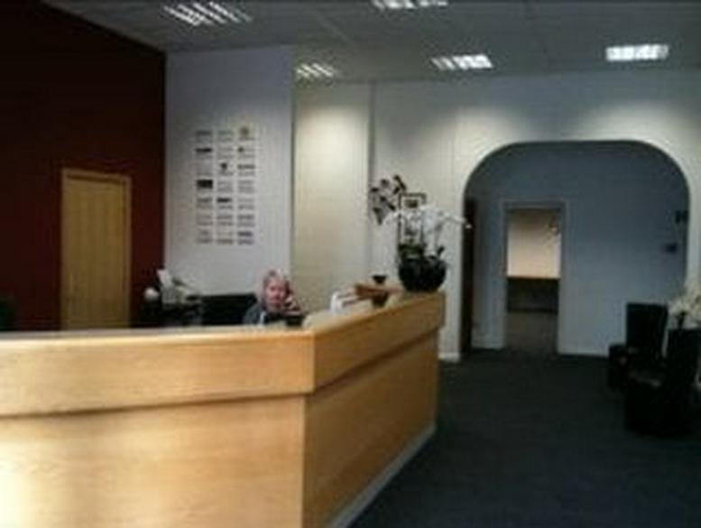 Wooden front desk at the Macclesfield Business Centre, Sunrise House featuring a large arched doorway.