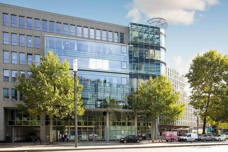 Exterior view of the contemporary glass and stone building at Mainzer Landstraße 69.
