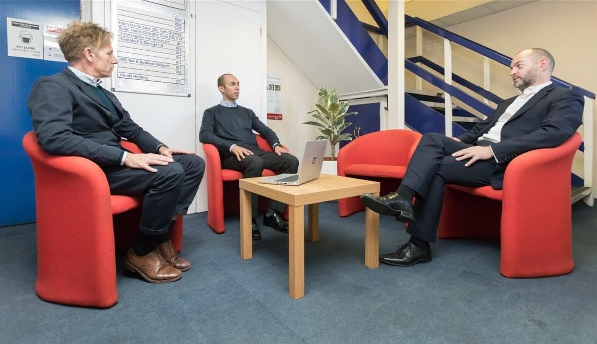 Bright reception area at Manor Road, West Ealing, North West London, W13, UK with red armchairs and wood coffee table.