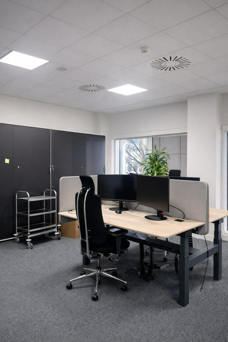 Four-person desk pod with privacy screens and ergonomic swivel chairs.