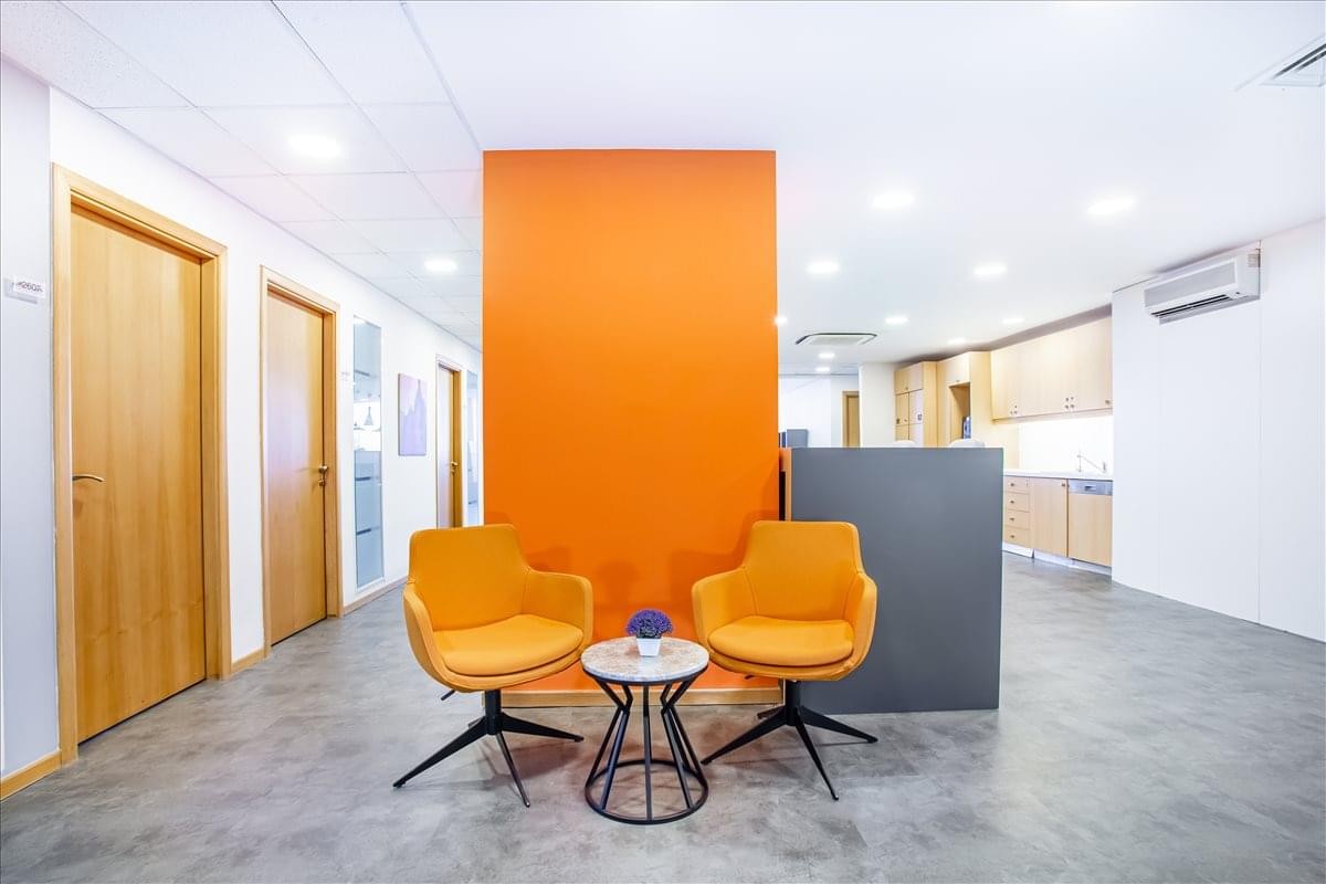 Bright reception area at Maslak Beybi Giz with orange feature wall and stylish lounge seating.