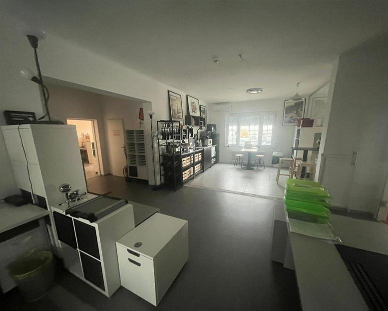 Spacious communal lounge area with various storage units and a wide entryway.