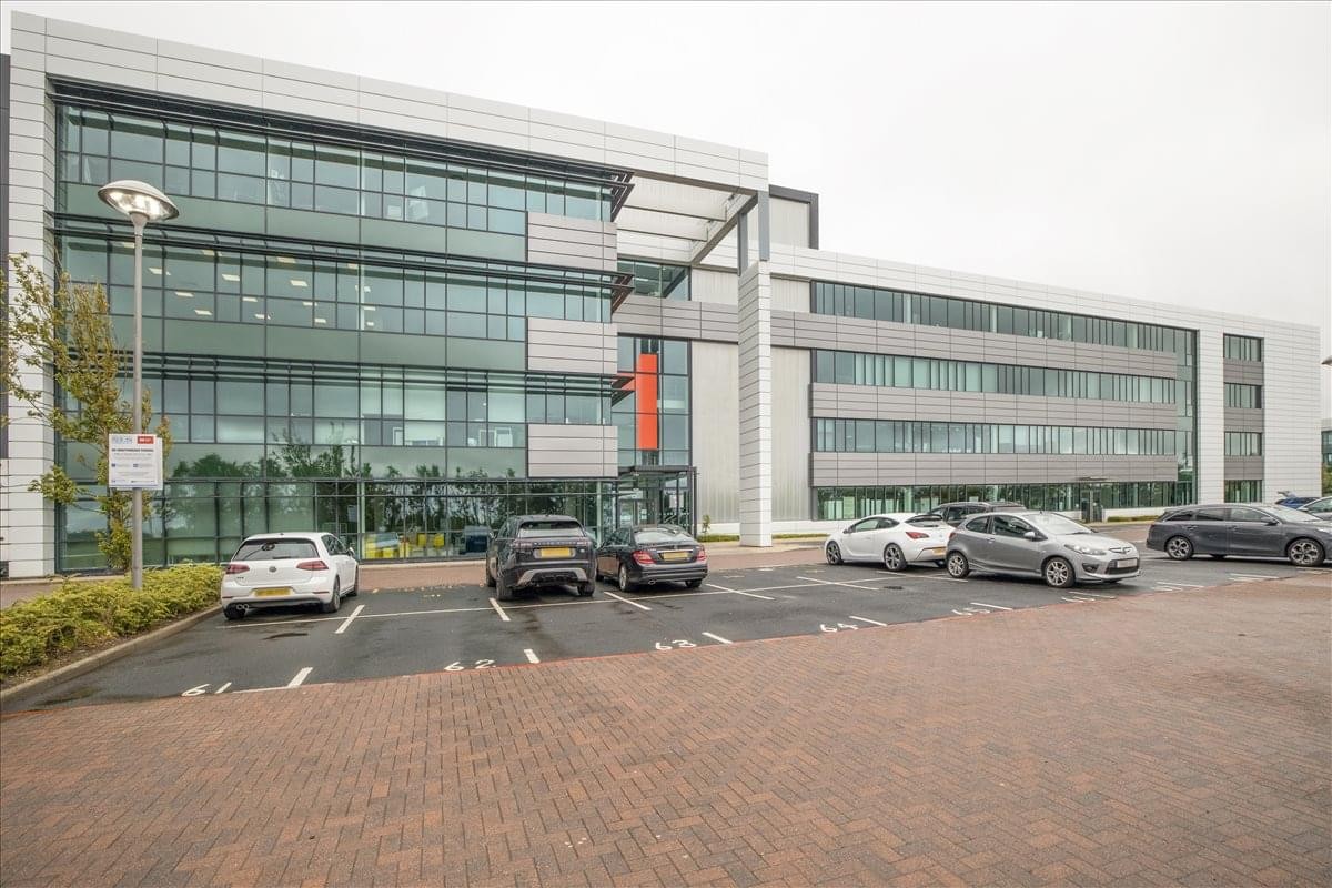 Exterior view of the contemporary glass-fronted Maxim Business Park building and parking lot.