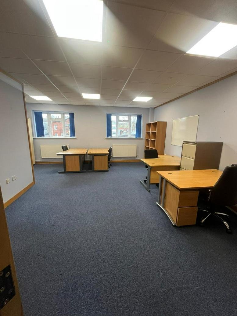 Spacious office suite at McCarthy’s Business Centre, Meanwood Road with multiple desks and blue carpeting.