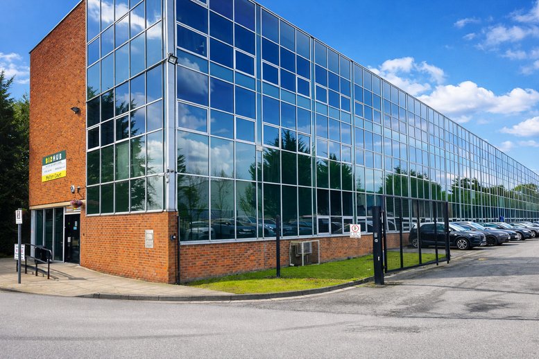 Exterior view of the glass-facade and brick Melton Court building on a sunny day.