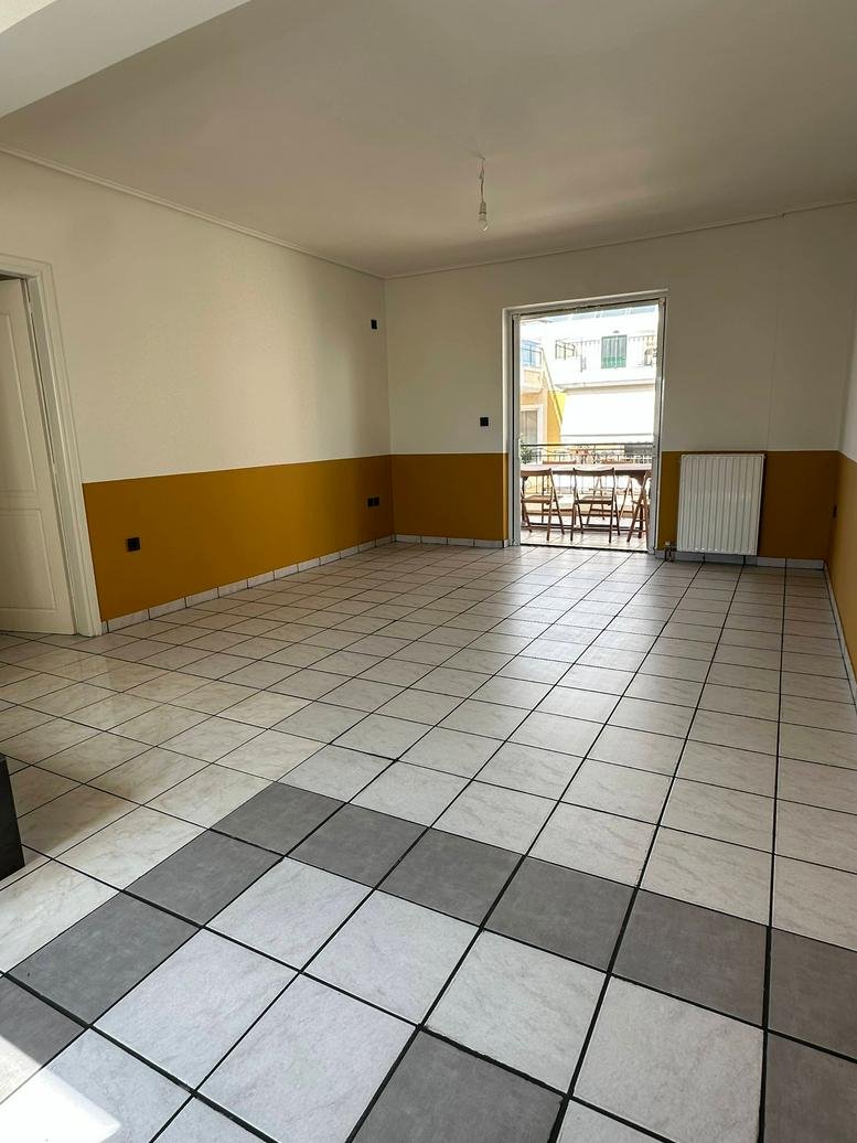 Spacious open-plan office at 14 Messinias Street with tiled flooring and yellow accent walls.