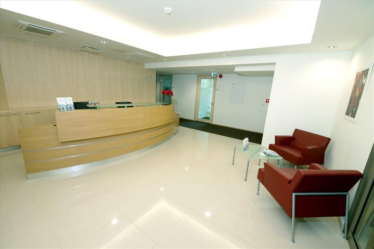Bright reception area of 3rd Floor, Metro Plaza, Viru Valjak 2 with wood desk and red lounge chairs.