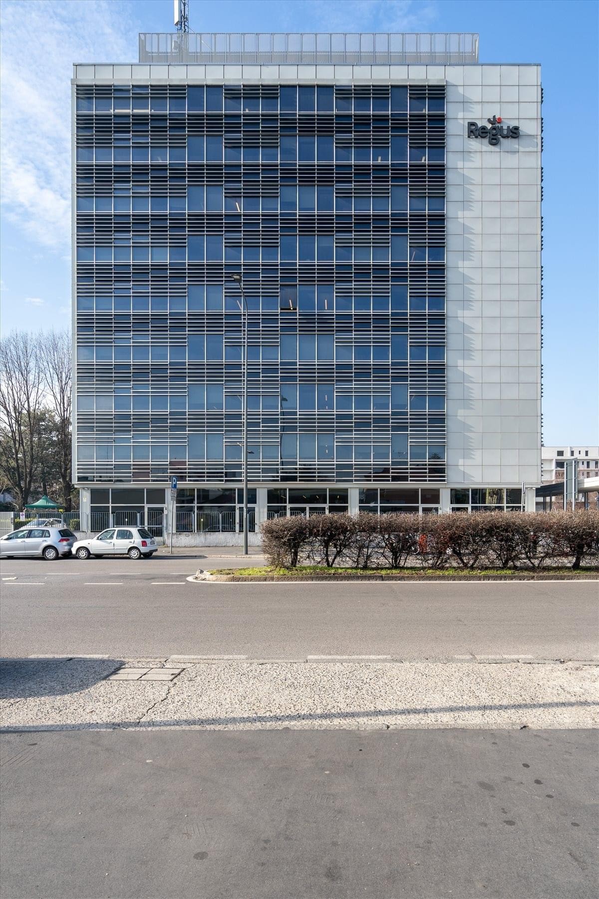 Modern communal kitchen and cafe area at Milan Viale Monza featuring a breakfast bar with stylish wooden stools.