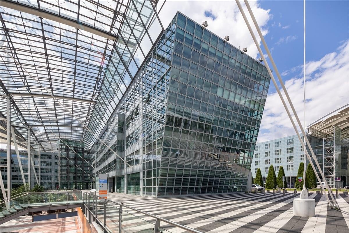 Exterior view of the modern glass-facade Munich Airport Centre with its striking geometric architecture.