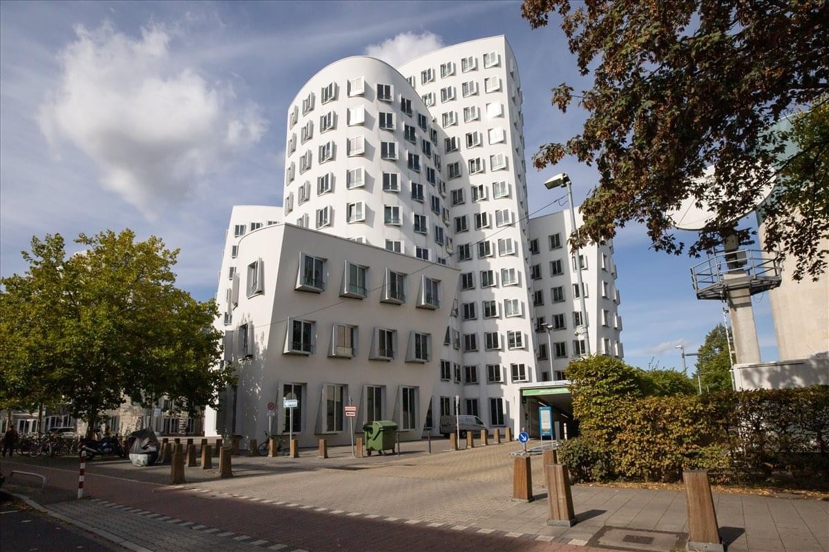 Exterior view of the iconic white curved facade of Neuer Zollhof 3.