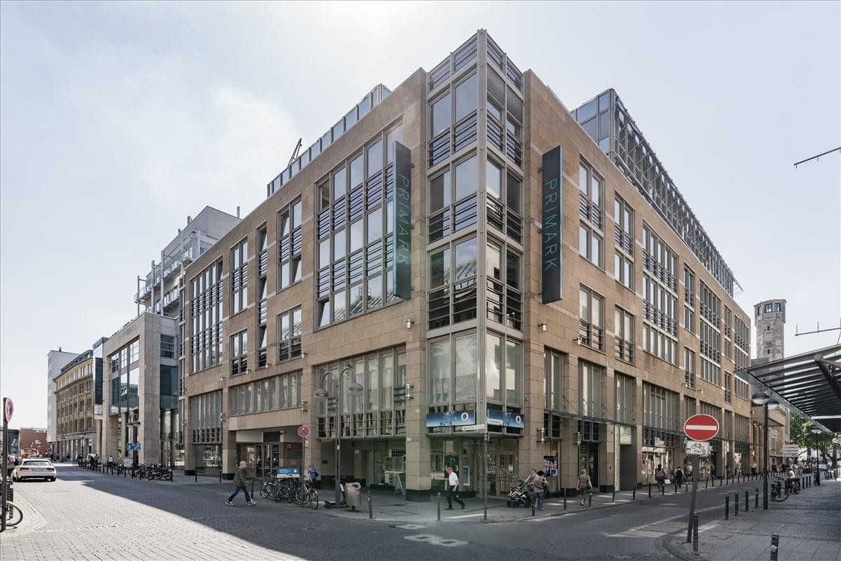 Exterior view of the modern Neumarkt-Galerie building with large glass windows on a city corner.