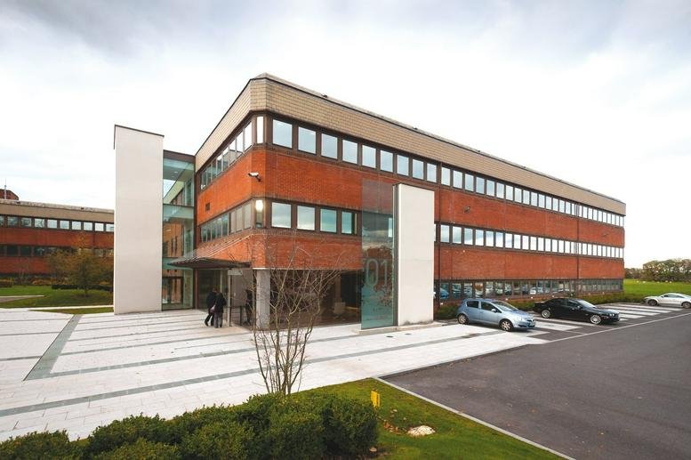 Exterior view of the brick and glass facade at 1 Booths Park, Chelford Road.