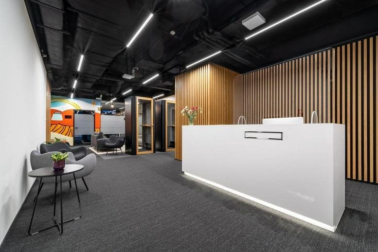 Reception desk at Nobilis Business House with wooden feature walls and modern lighting.