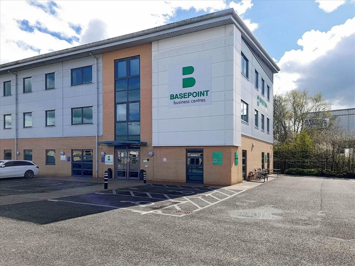 Exterior view of the multi-story Tewkesbury Business Park, Oakfield Close building under a blue sky.