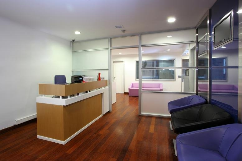 Reception area at Maslak Mahallesi Eydan Sokak No. 1 with a wooden desk and purple armchairs.