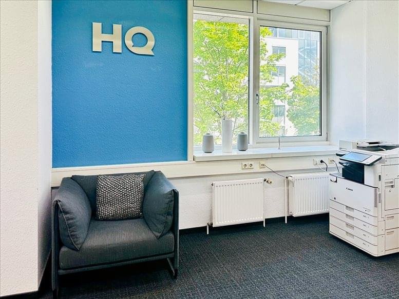Reception waiting area featuring a blue armchair and branded HQ signage on a blue feature wall.