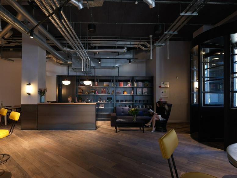 Spacious reception area at Old Street, 71 Central Street with a sleek desk, lounge seating, and industrial ceiling.