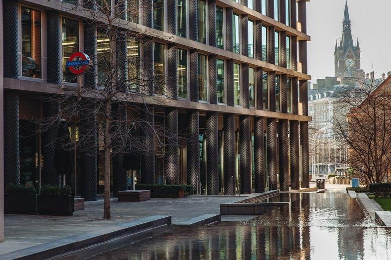 Modern architectural exterior of One Pancras Square, Kings Cross showing a grid facade and reflecting pool.