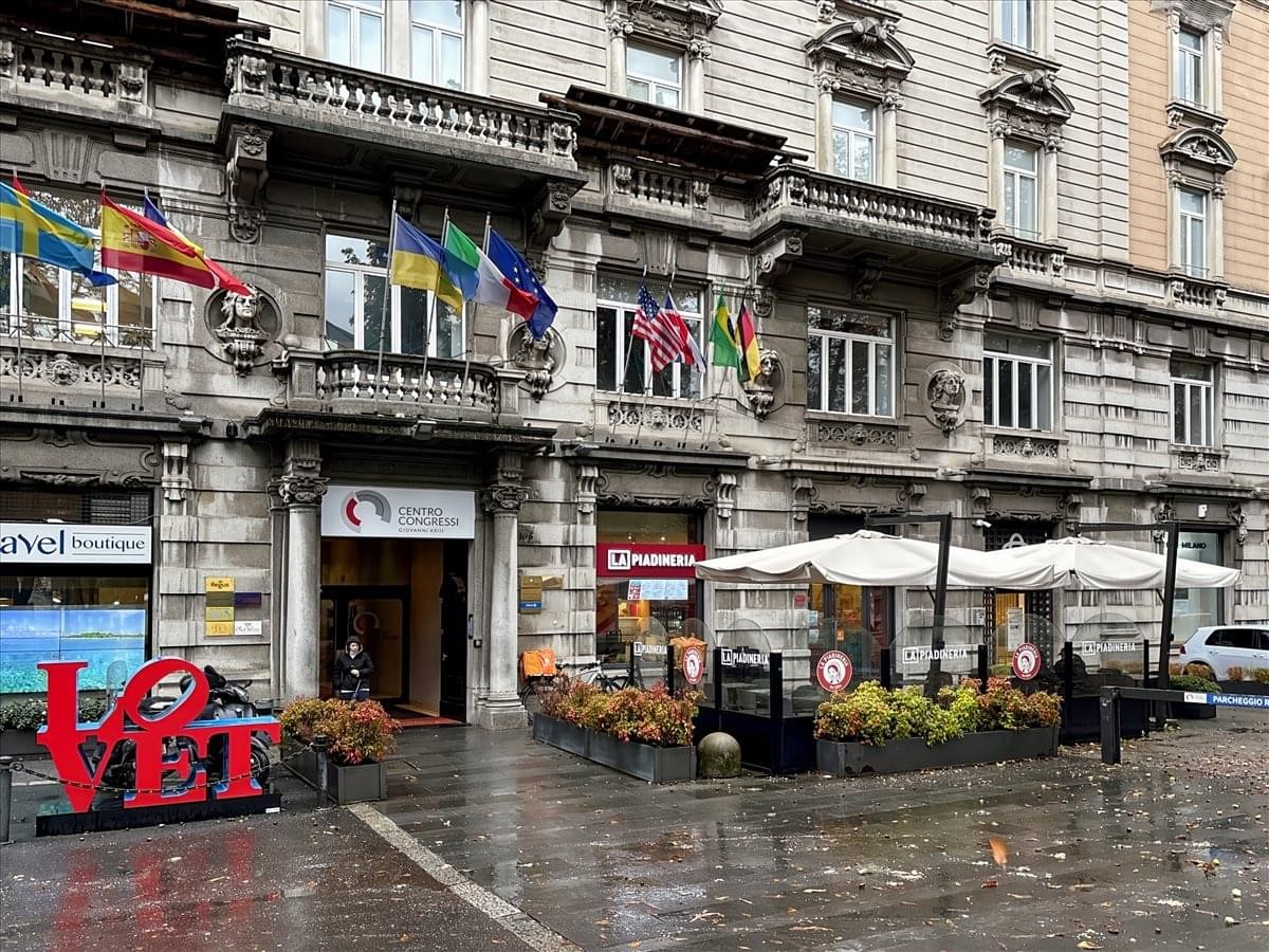 Grand historic facade of Palazzo Rezzara featuring arched windows and international flags.