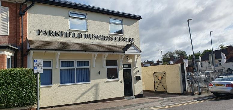 Exterior view of the cream-colored Parkfield Business Centre building under a cloudy sky.