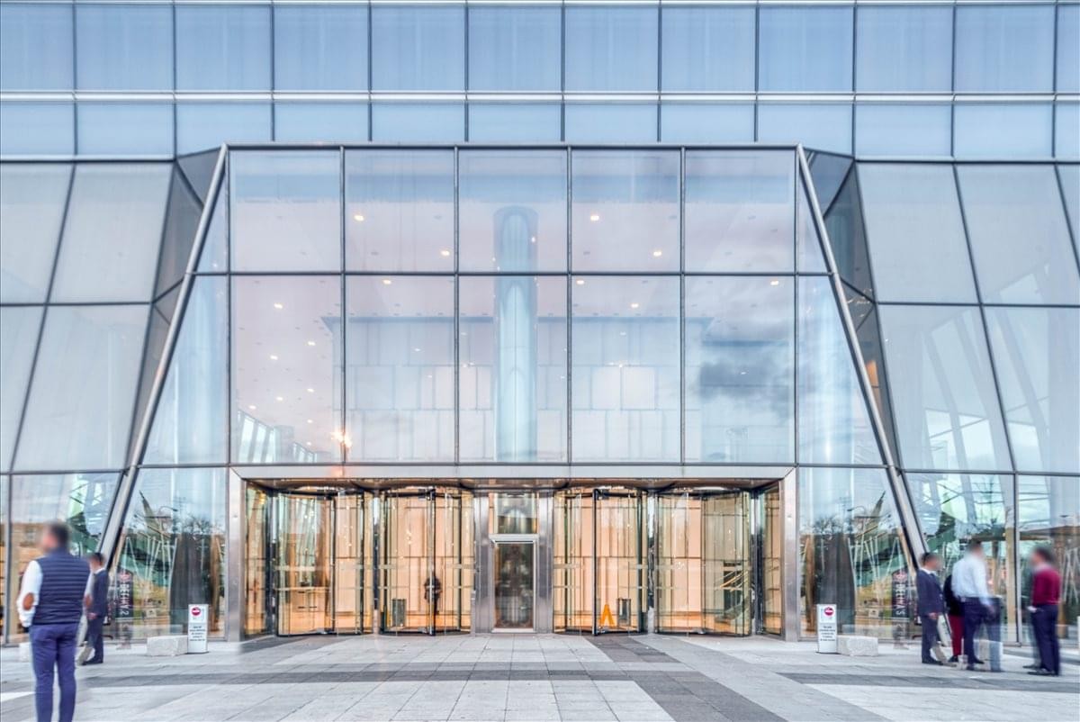 Exterior view of the grand glass entrance at the Torre de Cristal building.