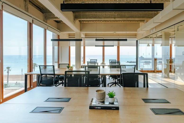 Spacious open-plan workspace at Passeig de Joan de Borbó 93, Port Vell with large windows overlooking the ocean.