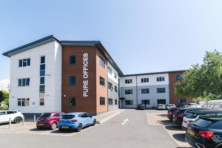 Exterior facade of Pure Offices at Pastures Avenue with brick and white cladding under a clear blue sky.