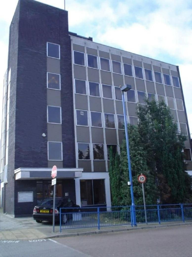 Exterior facade of the multi-story Pentax House with dark brick and glass paneling.