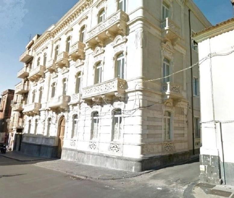 Exterior view of the historic neoclassical facade at Piazza Cavour, 14, Catania.