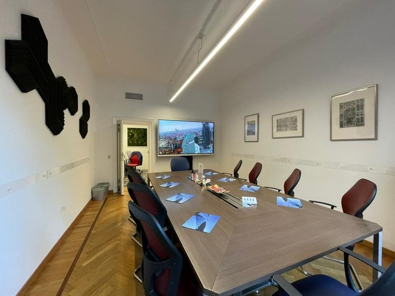Professional boardroom with a large wooden table and integrated presentation screen.