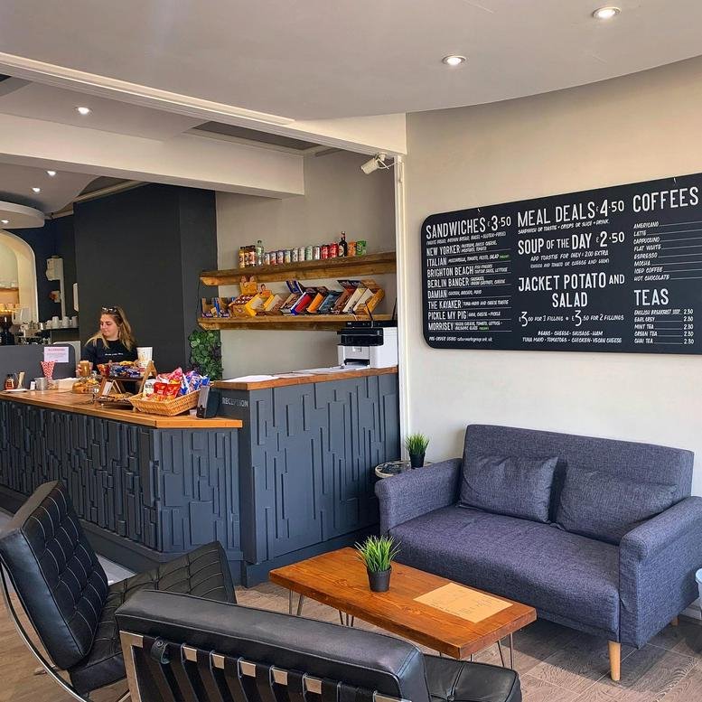 Cafe and reception area at Pier Werks, 21-22 Old Steine, with wood-topped counters and a blue sofa.