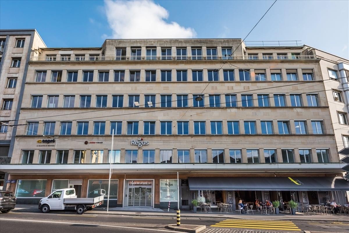 Exterior view of the classic stone facade building at Place de la Gare 12, Lausanne.