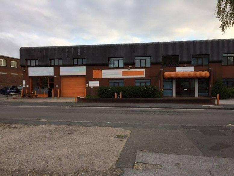 Exterior view of the brick-faced PMJ House with orange accent doors and a flat dark roofline.