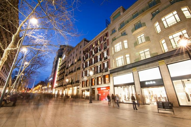 Low angle view of a commercial street with historic buildings at dusk.