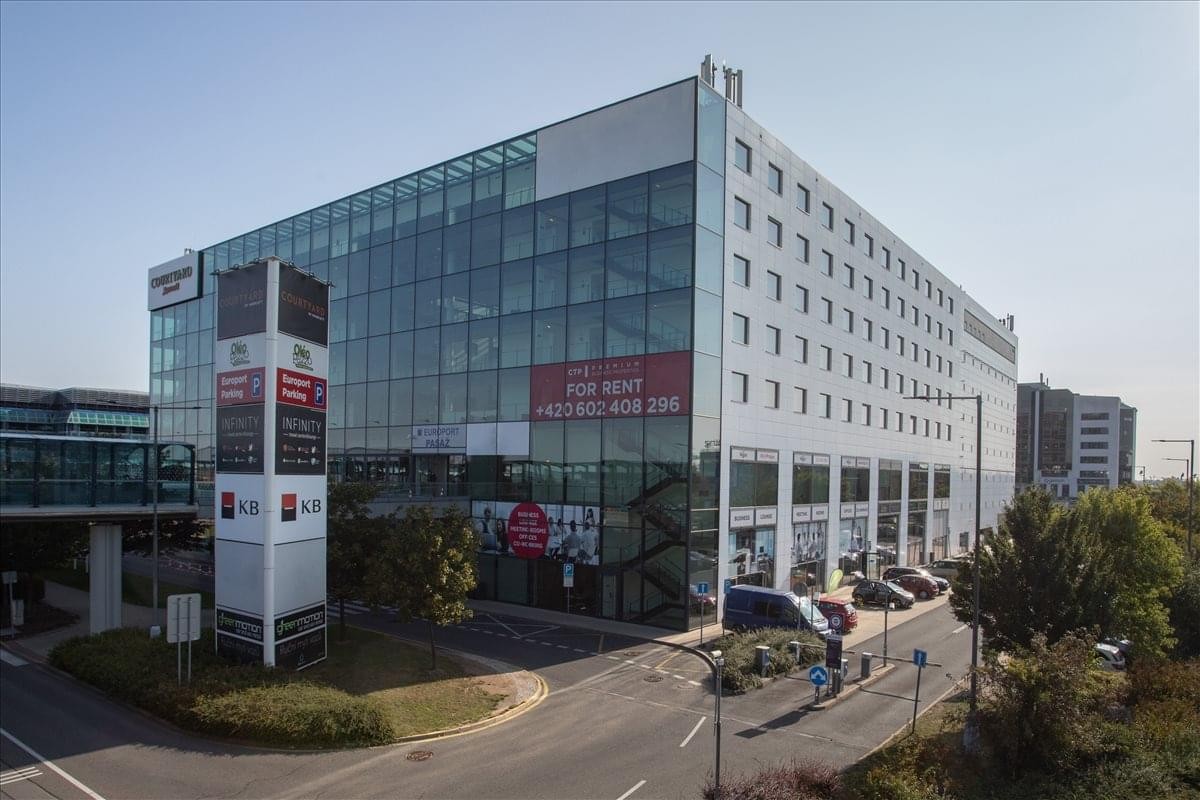 Exterior view of the modern glass-facade building at Prague Airport, Aviatická 1092/8.